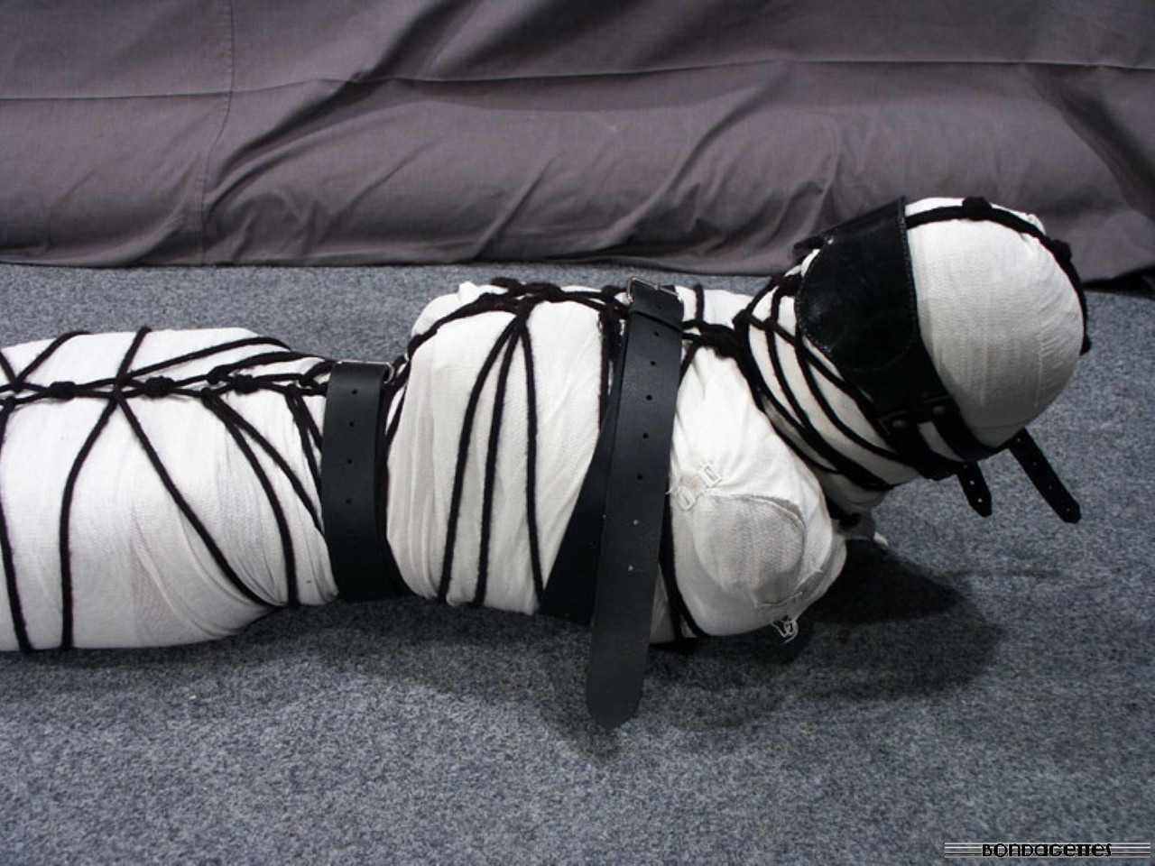 brunette chick wears hooped earrings while being mummified and tied up