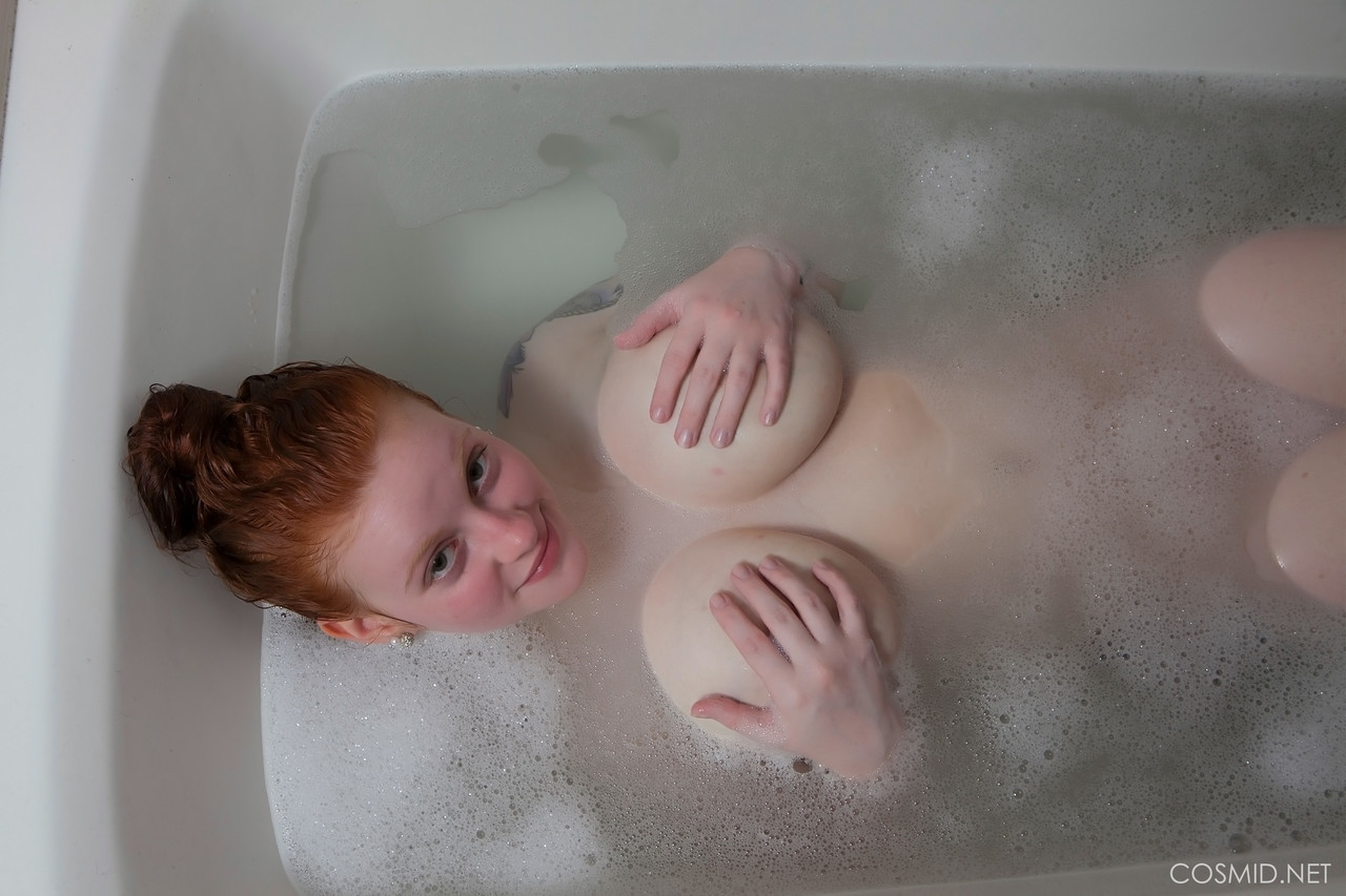pale redhead kaycee barnes displays her large boobs and butt during a bath