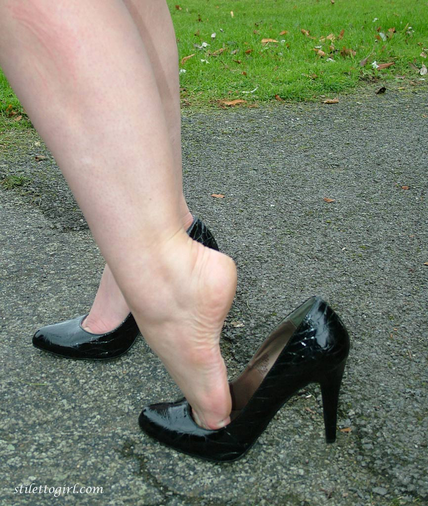 fully clothed model nicola takes a walk on park pathway in her new black pumps