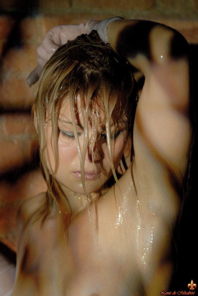 glamour model gets soaking wet during a solo shoot afore a brick wall