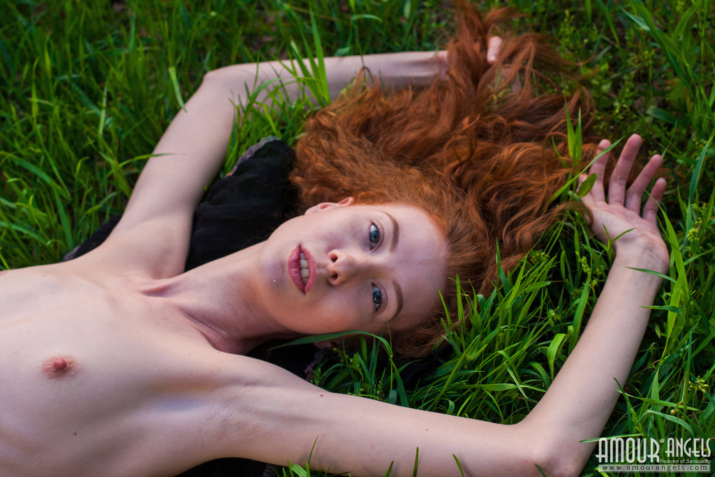 thin redhead veronika models totally naked on a blanket in a lush meadow